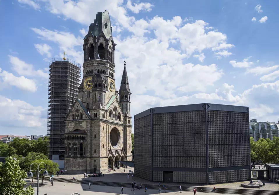 Kaiser-Wilhelm-Kirche, broken spire and modern bell tower overlook the busy Breitscheidplatz as symbols of the city's regeneration. Berlin, Germany